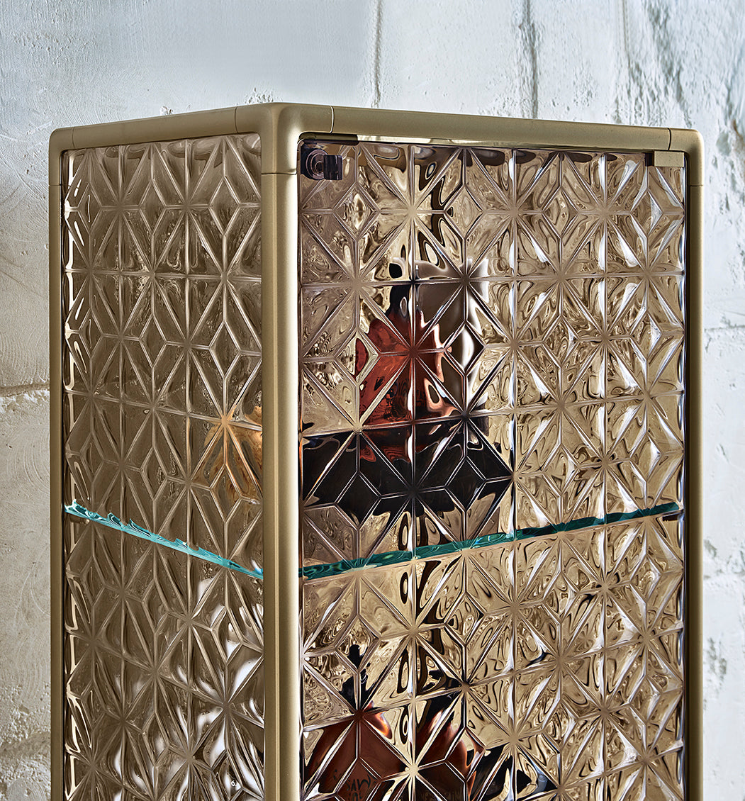 Echo display cabinet's 6 mm thick tempered and fused glass doors with 3D geometric textures on Champagne frame.