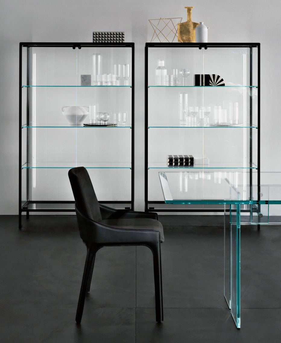 Modern glass display cabinets with black frames and a black chair