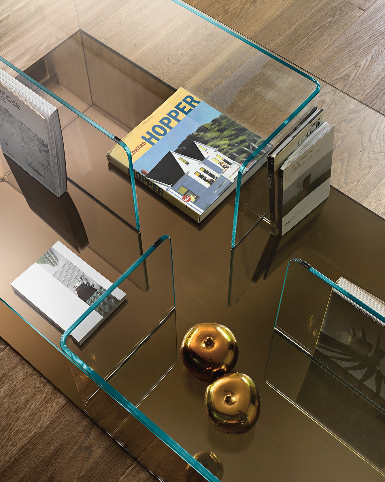 Quadra table base in back-silvered bronze glass showing curved glass craftsmanship.